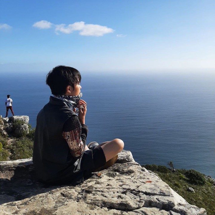 A Tilting Futures gap year travel program student looking out over the ocean from a mountaintop