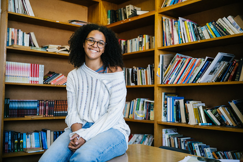 A Tilting Futures gap year travel program student smiling for the camera at a library