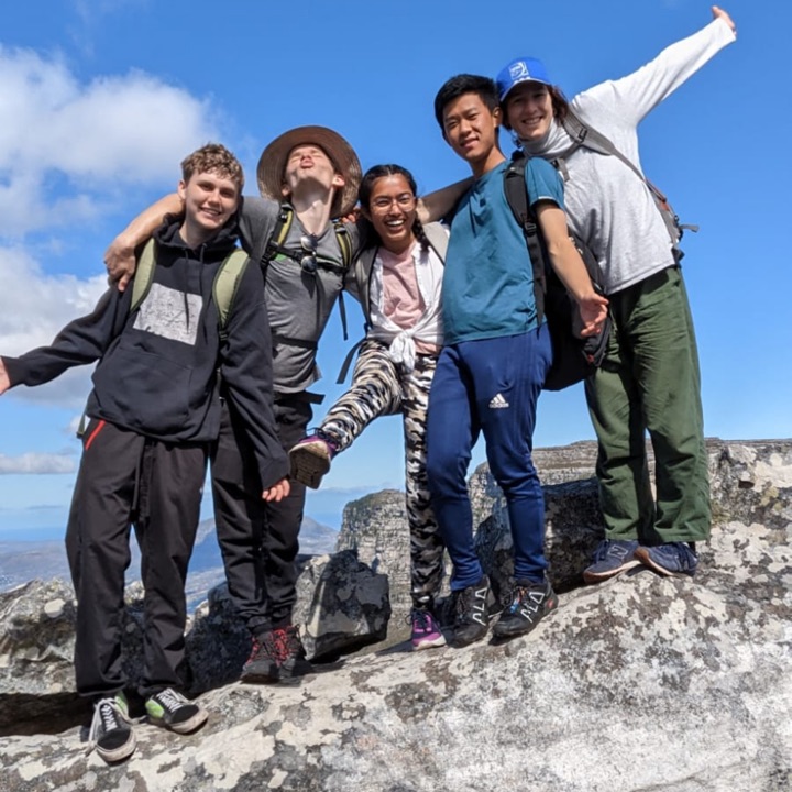 5 Tilting Futures gap year travel program students hanging out at the top of a mountain