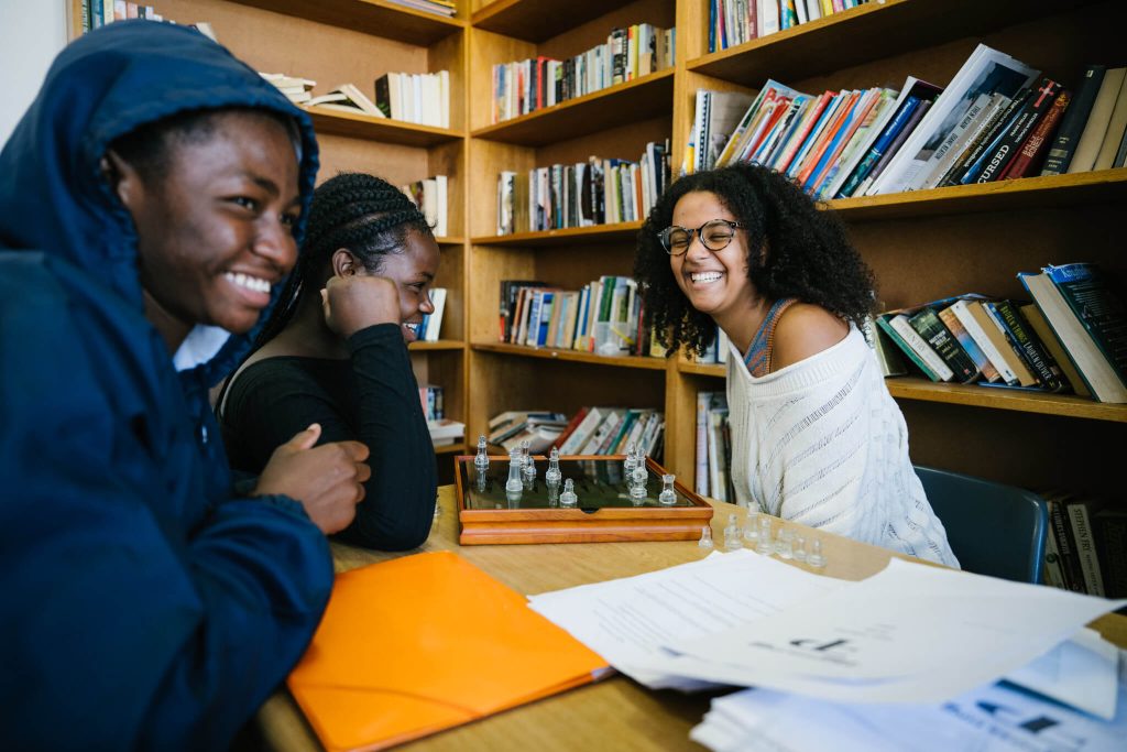 Students laughing together in a library at Tilting Futures gap year immersive learning program
